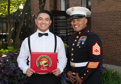 a graduate smiling with a marine